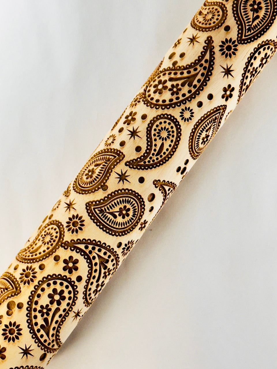 Rolling pin with black paisley pattern on a light background