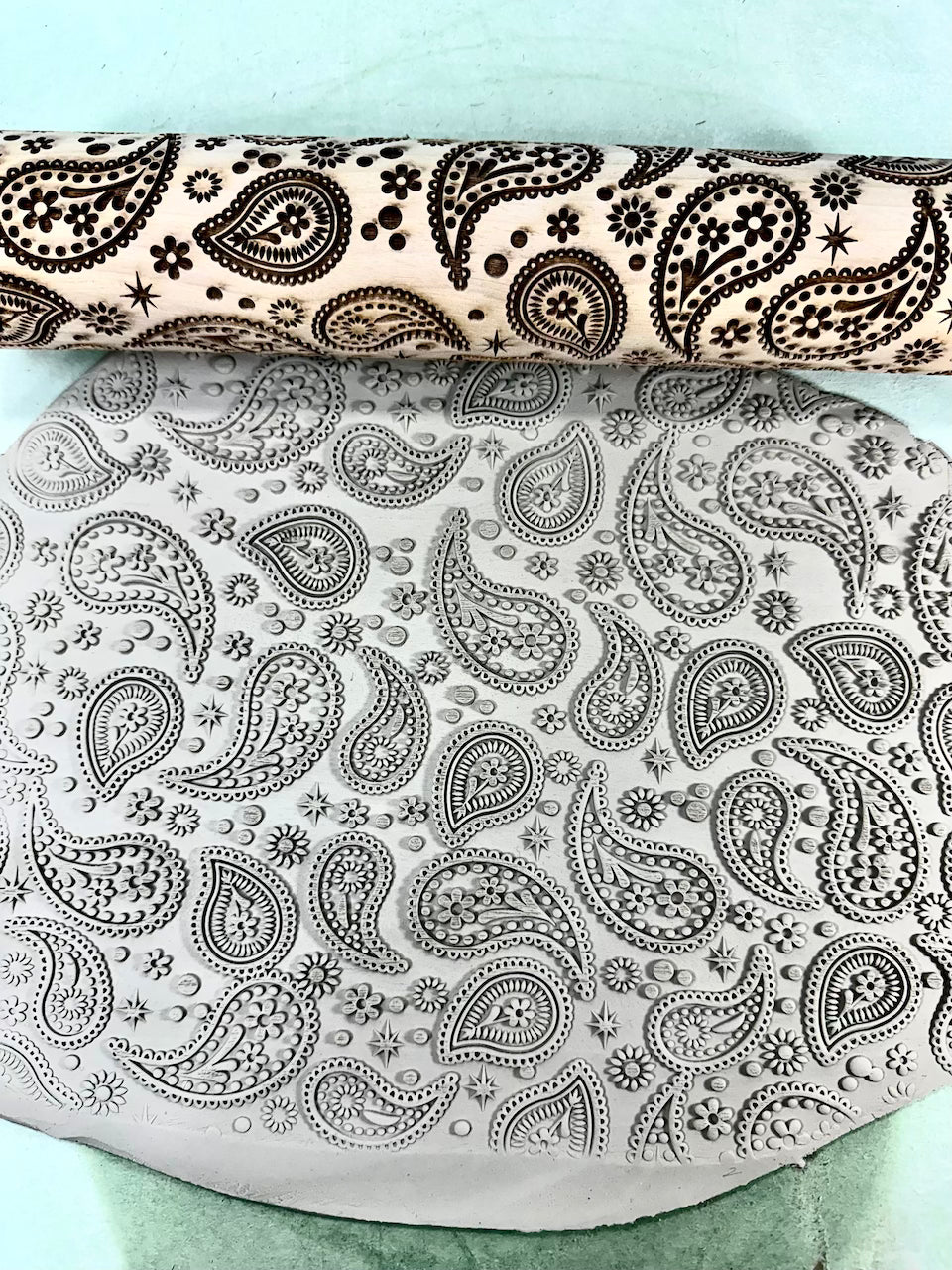 Rolling pin with paisley pattern on a light blue background